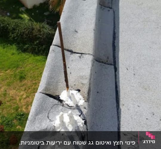 חומר איטום לבן על גג בטון עם מוט ברזל